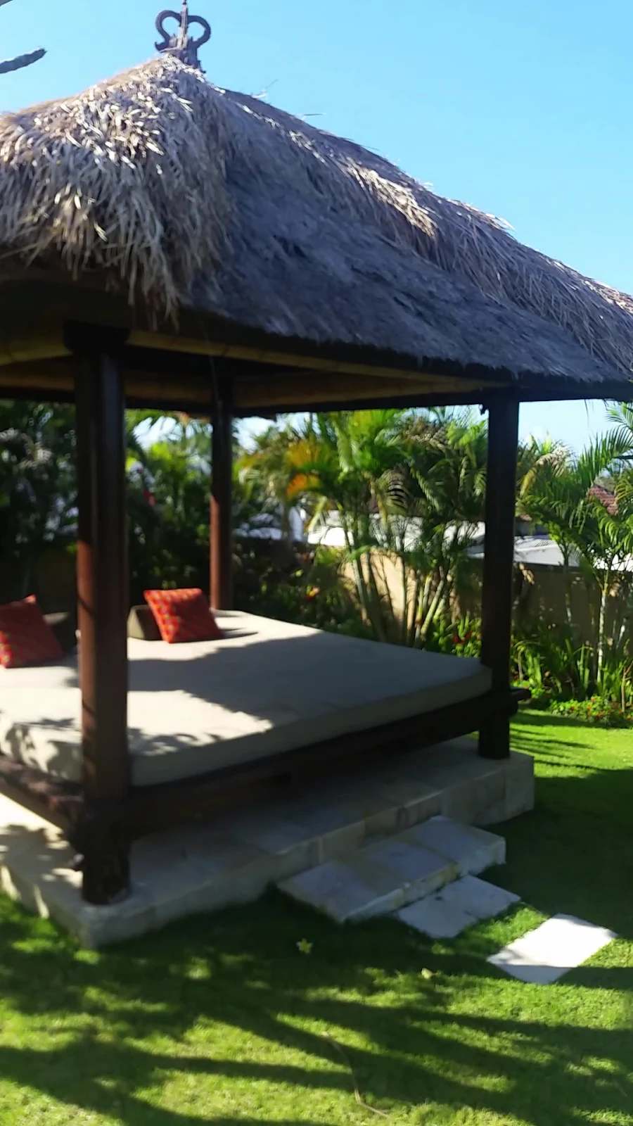 Traditional garden massage bale daybed in tropical lawn